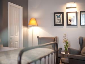 倫敦的住宿－The Warrington，一间卧室配有一张床、一把椅子和一盏灯