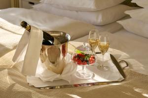 a tray with champagne and wine glasses on a bed at Hotel Diplomat Stockholm in Stockholm