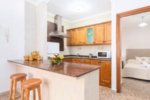 Una cocina con gabinetes de madera y encimera. en Home2Book Cozy Apt near the Beach in Gran Tarajal, en Gran Tarajal
