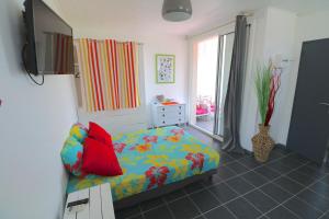 um quarto com uma cama e uma televisão em RESIDENCE COCO em Sainte-Anne