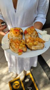 Domus Olea في بوليكاسترو بوسينتينو: شخص يحمل طبق من الطعام مع السندويشات