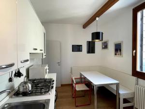 a kitchen with a stove and a table and a counter at Bella Vista apartment in Venice