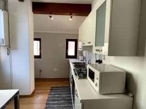 a kitchen with a stove and a microwave on a counter at Bella Vista apartment in Venice