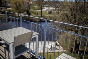 un banco blanco sentado en un balcón junto a un cuerpo de agua en Hotell Villa Rönne, en Ängelholm