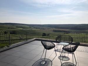 einen Balkon mit 2 Stühlen und Blick auf die Landschaft in der Unterkunft FLORESSENS EN CHAMPAGNE Terrasse privative sur le vignoble in Fleury-la-Rivière