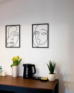 tre stampe artistiche incorniciate di volti su un muro di Corvin Guesthouse a Hunedoara