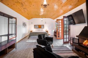 sala de estar con cama y chimenea en Pousada Recanto Vila das Flores, en Campos do Jordão