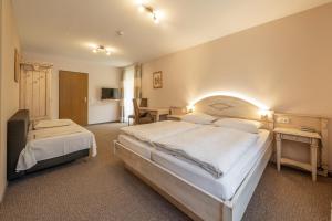 a hotel room with two beds and a desk at Café Pension Leistner in Obertrubach