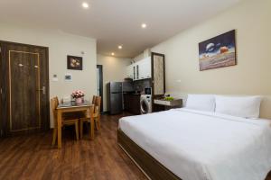 a bedroom with a large bed and a kitchen at YR Hotel & Apartments in Hanoi