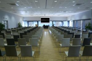 a large room with rows of chairs and a screen at Cosmopolitan Hotel in Civitanova Marche