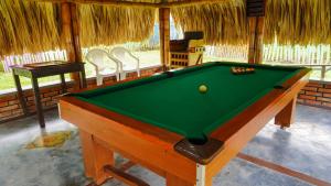 a pool table in a room with a pool at Hostal De Paris in Pueblo Tapao