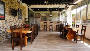 a restaurant with wooden tables and chairs in a room at Hostal De Paris in Pueblo Tapao