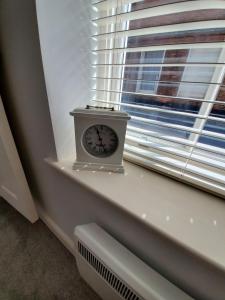 a clock sitting on a window sill next to a window at Ipswich Town Centre - Apartment 1 in Ipswich