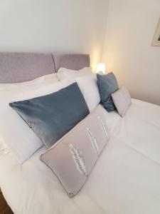 a white bed with several pillows on it at Ipswich Town Centre - Apartment 1 in Ipswich