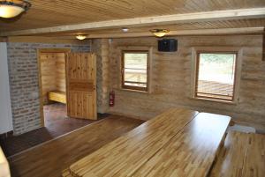 Zimmer mit einem Holztisch in einem Zimmer mit Fenstern in der Unterkunft Vilks un Briedis Holiday Home & Wellness Area in Smiltene