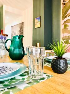 a table with a green pitcher and a glass on it at Appartement Lavande et Jasmin in Anduze