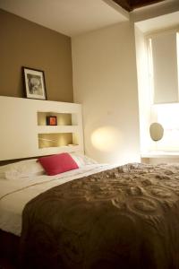 1 dormitorio con cama grande y almohada roja en Sèvres-Raspail Paris 6 apartment, en París
