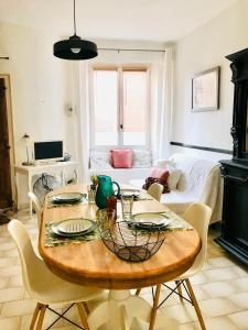 a living room with a table and a couch at Appartement Lavande et Jasmin in Anduze