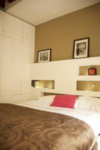 1 dormitorio con cama blanca y almohada roja en Sèvres-Raspail Paris 6 apartment, en París