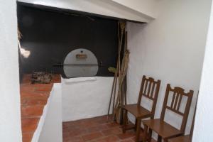 ein Zimmer mit 2 Stühlen und einer Wand mit einer Tür in der Unterkunft Casa Vitória in São Brás de Alportel