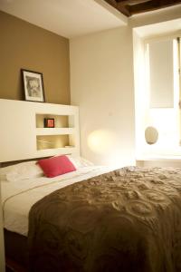 1 dormitorio con cama grande y almohada roja en Sèvres-Raspail Paris 6 apartment, en París