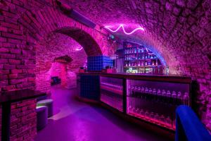 a bar with purple lights in a brick wall at Draggo House - Premium Rooms - Old Town in Krakow