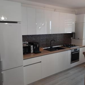 a kitchen with white cabinets and a sink at NEW Aparthotel Floresti in Floreşti