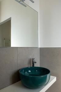 La salle de bains est pourvue d'un lavabo bleu et d'un miroir. dans l'établissement Allegroitalia La Spezia 5 Terre, à La Spezia