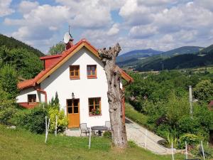 una piccola casa bianca con un albero accanto di charming house with beautiful landscape a Frýdštejn