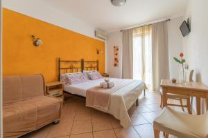 a bedroom with a bed and a couch and a table at Agriturismo Costadoro in Bardolino