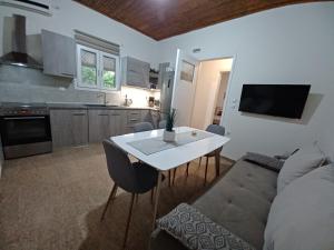 uma cozinha e sala de estar com uma mesa e um sofá em Beach House for up to 9 people near Olympia em Katakolon