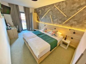 a bedroom with a large bed in a room at 16 Lakes Hotel in Grabovac