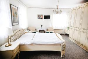a bedroom with a large bed and two chairs at Stáj Newport in Dolní Domaslavice