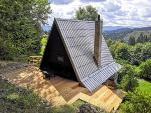 a small house with a roof on a wooden deck at Chaty Pohoda na Soláni in Velké Karlovice