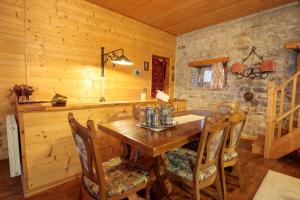 a dining room with a wooden table and chairs at La finestra sulla contea in Ovaro