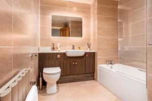 a bathroom with a toilet and a sink and a tub at London Gate No1 - Donnini Apartments in Kilmarnock