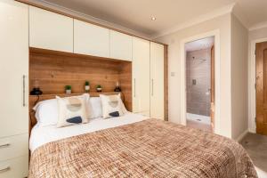 a bedroom with a large bed with white cabinets at London Gate No1 - Donnini Apartments in Kilmarnock