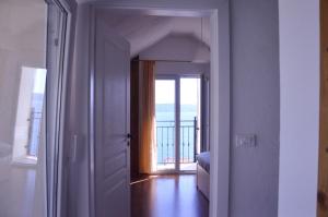 a hallway with a door leading to a room with a balcony at Old stone house Klarić in Brela