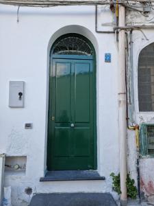 zielone drzwi na boku budynku w obiekcie La casa nel duomo Vietri sul Mare w mieście Vietri sul Mare