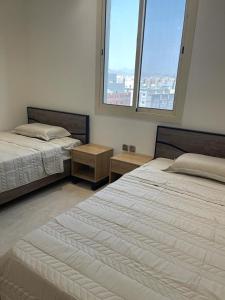 two beds in a room with two windows at أفخم شقة فندقيه بالقرب من الحرم المكي in Mecca