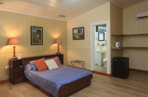 a bedroom with a bed and a bathroom at Horquetas River Lodge in Sarapiquí