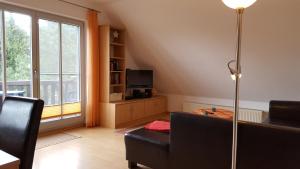 uma sala de estar com um sofá e uma mesa em Fewo Heinke im Reetdachhaus Fewo cc em Kolpinsee