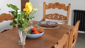 uma mesa de madeira com um vaso de flores e uma taça de fruta em Courtyard Cottage at Stepps House em Ilminster