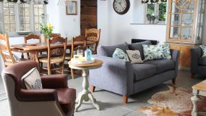 a living room with a couch and a table at Courtyard Cottage at Stepps House in Ilminster