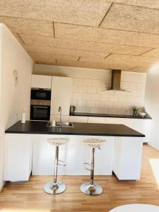 a kitchen with a counter and two stools at aday - Nice and cozy place in Aalborg