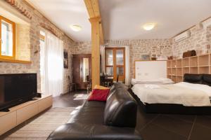 a bedroom with a couch and a bed and a tv at Galera in Šibenik