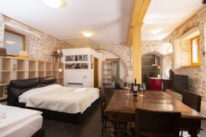 a bedroom with a bed and a dining room with a table at Galera I in Šibenik