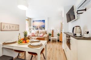 Il dispose d'une cuisine et d'un salon avec une table et des fruits. dans l'établissement Modern 1 BR apartement in very center of Marbella., à Marbella