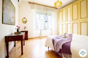 een slaapkamer met een bed, een tafel en een raam bij Sunny Corner Apartment in Pisa