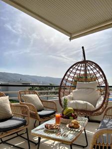 a porch with chairs and a table and a swing at Nidus 101 in Souda